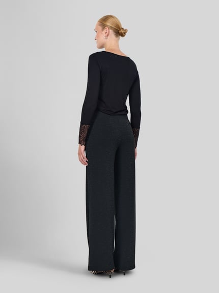 Frauenmodel trägt Weite Hose mit Strukturoptik von Soyaconcept in Schwarz mit weitem Bein aus Polyester-Mix, Ganzkörperansicht Rückansicht