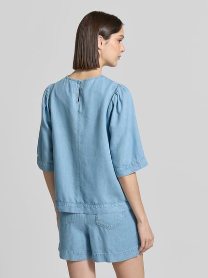 Frauenmodel trägt Regular Fit Bluse in Denim-Optik von Rich & Royal aus Reine Baumwolle mit Rundhalsausschnitt und Knopfverschluss, Ganzkörperansicht Rückansicht.