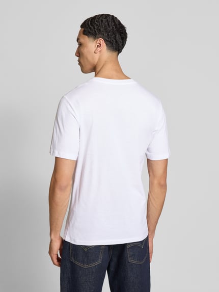 Männermodel trägt Regular Fit T-shirt aus puur katoen model 'COLE' van Jack & Jones, witte kleur, labelprint, ruglengte maat M 70 cm, ganzlichaamsaanzicht achteraan.