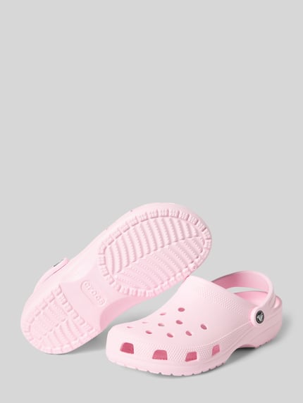Produktfoto, Clogs mit Label-Detail von Crocs in zartem Rosa, Abgerundete-Spitze, Schlupfform, verstellbarer Riemen, Absatzhöhe: 4 cm bei Größe 39/40.