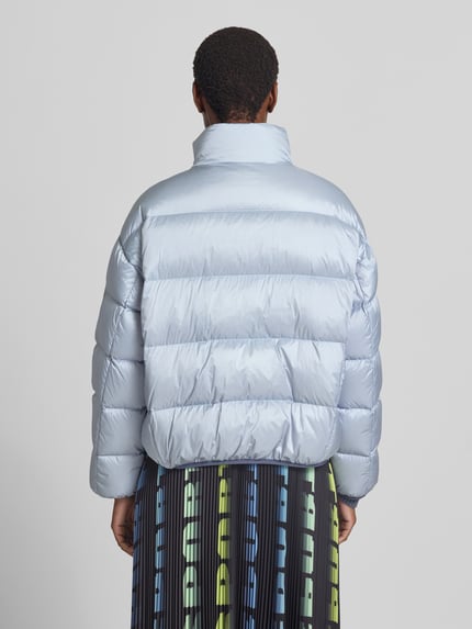 Frauenmodel trägt Regular Fit Jacke in Stepp-Optik mit Stehkragen von Marc Cain in Hellblau, elastische Abschlüsse, Ganzkörperansicht Rückansicht.