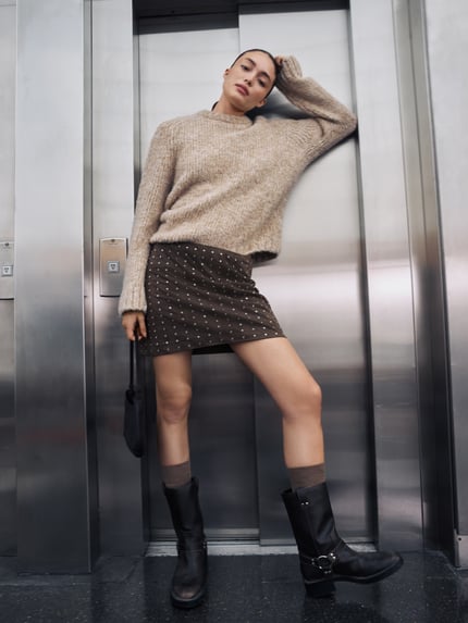 Kobiece model nosi Oversized Strickpullover mit Rundhalsausschnitt od Jake*s Casual, sweter z dzianiny, krój oversized, okrągły dekolt, długość tyłu w rozmiarze M: 49 cm, długość rękawów w rozmiarze M: 65 cm; kolor beżowy, tło metaliczne; pełny widok z przodu.