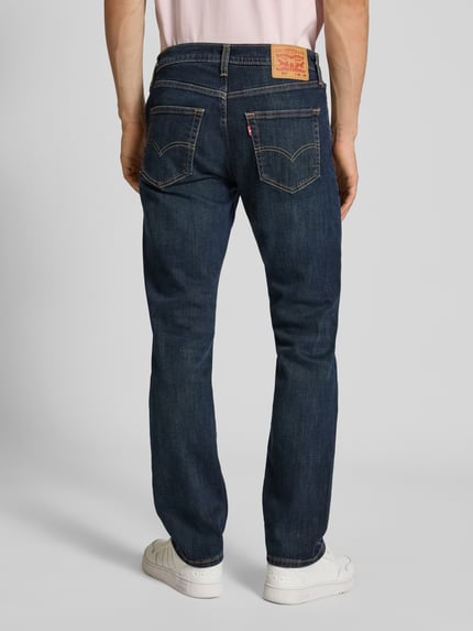 Männermodel trägt Slim Fit Jeans aus Baumwoll-Mix Modell '511™' von Levi's®, donkerblauw, vijf zakken, elastisch materiaal, Ganzkörperansicht Rückansicht.