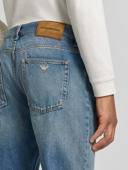 Männermodel trägt Straight Fit Jeans im 5-Pocket-Design von Emporio Armani aus reiner Baumwolle, Detailaufnahme Rückansicht.