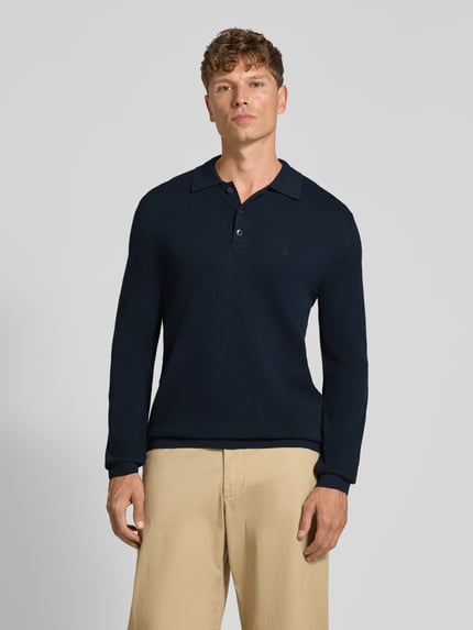 Männermodel trägt Poloshirt mit Logo-Stitching von MARC O'POLO in Dunkelblau, Piqué-Struktur, Regular Fit, Ganzkörperansicht von vorne