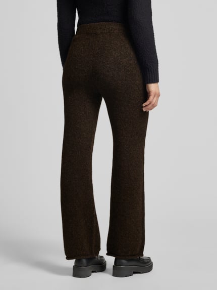 Frauenmodel trägt Hose mit Strickoptik von VERO MODA in Dunkelbraun, weites Bein, elastischer Bund, Strickmaterial, Ganzkörperansicht Rückansicht.