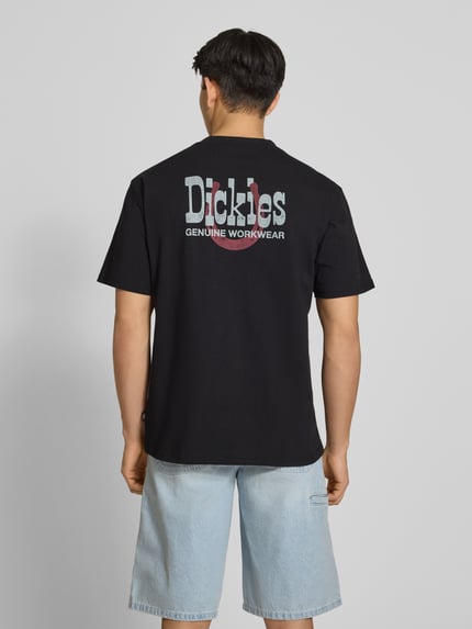 Mężczyzna model nosi męski t-shirt z logo model 'VERNAL' od Dickies, bawełna, krój relaxed fit, okrągły dekolt, długość tyłu w rozmiarze M: 74 cm, zdjęcie całej sylwetki z tyłu.