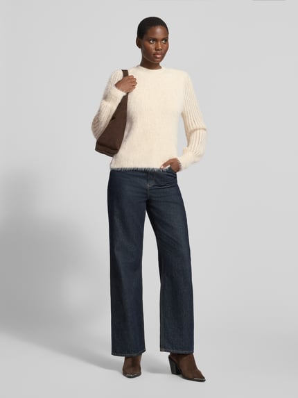 Modelka prezentuje Regular Fit Strickpullover aus Baumwoll-Mix mit Viskose-Anteil od zero, kremowy sweter z dzianiny o Stójce, prążkowane wykończenia, mieszanka bawełny i wiskozy, długość tyłu w rozmiarze 36: 52 cm, długość rękawów: 69 cm, widok całej sylwetki z przodu.