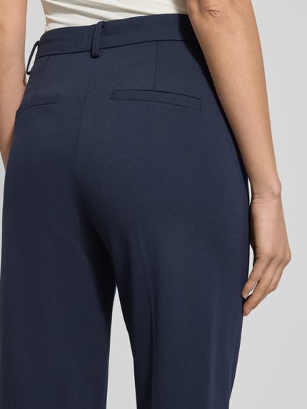 Frauenmodel trägt dunkelblaue Stoffhose mit Gesäßtaschen Modell 'SCLARINO' von Marella, Viskose-Mix, lockerer Schnitt, Detailaufnahme Rückansicht.