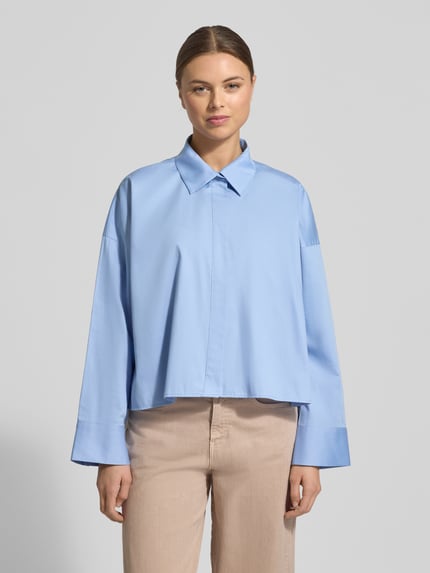 Frauenmodel trägt Hemdbluse mit verdeckter Knopfleiste Modell 'Fundra' von OPUS in Hellblau aus reiner Baumwolle, lockerer Schnitt, Hemdblusenkragen, vorne Ganzkörperansicht.
