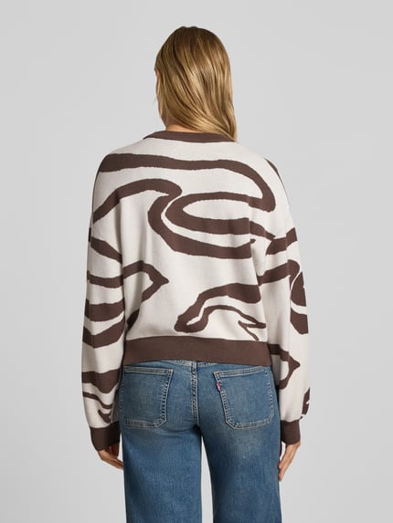 Modelka kobieca nosi Relaxed Fit Pullover aus Viskose-Mix Modell 'Charlott' od NOISY MAY®, kremowo-brązowy animal-print, prążkowane wykończenia, długi rękaw, okrągły dekolt, widok całej sylwetki z tyłu.