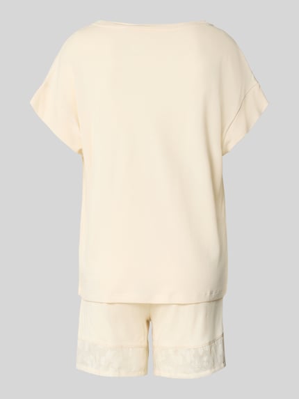 Frauenmodel trägt Pyjama aus Modal-Mix von Schiesser in Creme mit gerader Passform, Rundhalsausschnitt und semitransparenten Details, Ganzkörperansicht Rückansicht.