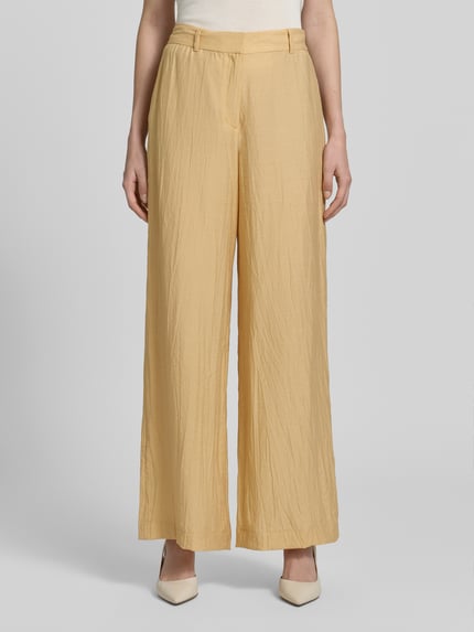 Frauenmodel trägt Hose aus Viskose-Mix in Crinkle-Optik von Jake*s Collection, gelb, Regular-Fit, Gesäßtaschen, Ganzkörperansicht von vorne.
