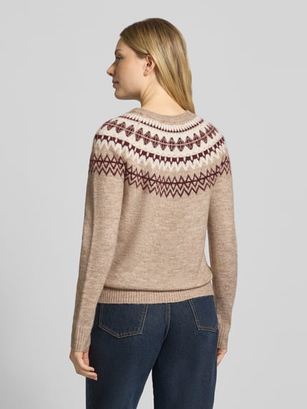 Frauenmodel trägt Pullover mit kontrastreichem Rundhals-Strickmuster von VERO MODA, mehrfarbig, florales und geometrisches Jacquardmuster, Feinstrick, Ganzkörperansicht Rückansicht.