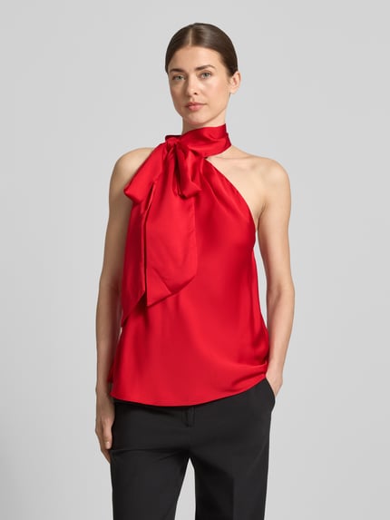 Vrouwenmodel draagt Shaped Fit Top met Schnürdetail van Lauren Ralph Lauren in effen rood met satijnlook, hals met halter en bindceintuur, mouwloos ontwerp, materiaalverwerking satijn. Nahaufnahme Oberkörper.