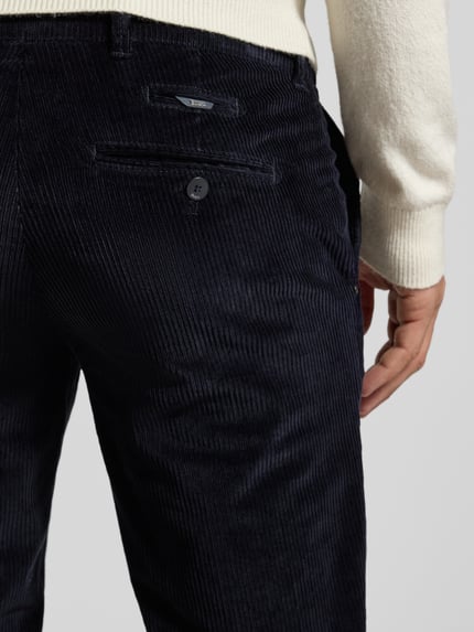 Männermodel trägt Slim Fit Cordhose mit Gesäßtaschen Modell 'Fabio' von Brax, dunkelblau, feine Rippenstruktur, Detailaufnahme Rückansicht. Elastischer Baumwoll-Mix, Bundweite 42 cm, Innenbeinlänge 82 cm, Knopf- und Reißverschluss.