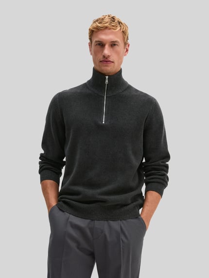 Männermodel trägt Pullover mit halblangem Reißverschluss von MARC O'POLO, unifarben, Strukturstrick, hochgeschlossener Troyerkragen, Ganzkörperansicht von vorne.