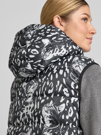 Frauenmodel trägt Regular Fit Weste mit Wendefunktion von Marc Cain im schwarz-weißen Animal-Print mit Katzenmotiv, Nahaufnahme Oberkörper, Damen Weste von Marc Cain