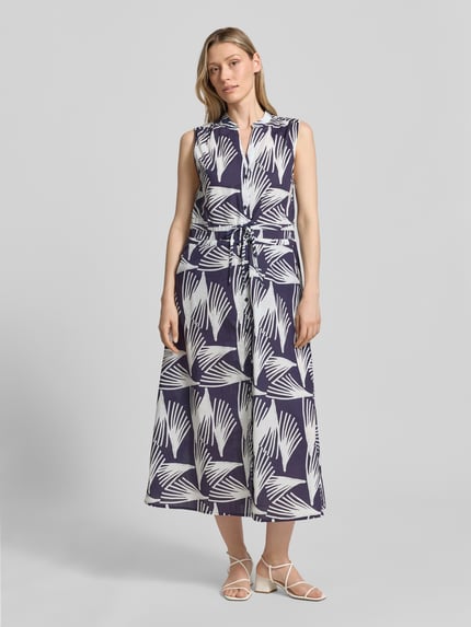 Frauenmodel trägt Hemdblusenkleid mit V-Ausschnitt und Bindegürtel Modell 'Lani' von GUIDO MARIA KRETSCHMER WOMAN aus reiner Baumwolle im Allover-Look, blaue und weiße Farben, A-Linie, Midikleid, Knopfleiste, Ganzkörperansicht von vorne.