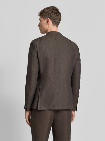 Męski model nosi Slim Fit 2-Knopf-Sakko aus Leinen Modell 'Hoverest' von JOOP! Collection w kolorze brązowym, nakładane kieszenie, długość tyłu 73 cm, szerokość w rozmiarze 50: 49 cm, długość rękawów 65 cm, kołnierz z połami, krój slim fit, widok całej sylwetki z tyłu.