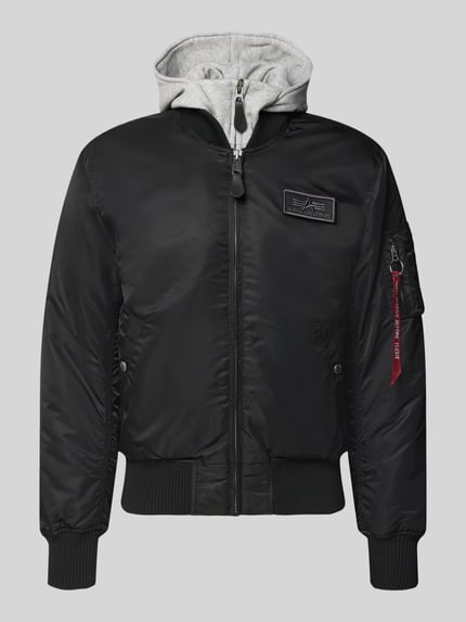 Produktfoto, Jacke mit Reißverschlusstasche am Ärmel von Alpha Industries in Schwarz, reguläre Passform, gerippte Abschlüsse, graue Kapuze, Reißverschluss, Label-Patch, strukturierte Oberfläche.