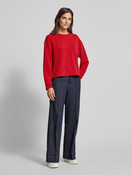 Vrouwenmodel draagt Regular Fit sweatshirt uit modalmix van s.Oliver RED LABEL, effen look, reliëflogo, ronde hals, lange mouw, sweat materiaal, geribde mouwboord, geheel vooraanzicht.