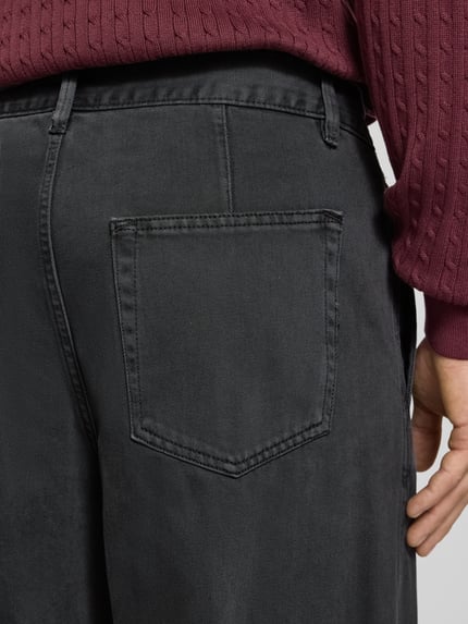Männermodel trägt Straight Fit Stoffhose aus reiner Baumwolle von Lindbergh, schwarze Farbe, Detailaufnahme Rückansicht, Eingrifftaschen, Baumwollstruktur.