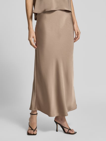 Frauenmodel trägt Maxirock aus Satin Modell 'Vicky' von Neo Noir in Beige, A-Linie, elastischer Bund, Nahaufnahme Unterkörper.