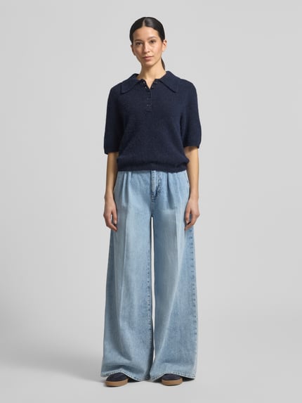 Frauenmodel trägt Wide Leg Jeans Modell 'Emanuela' von JOOP! aus Reine Baumwolle mit Gelegten Falten und Gesäßtaschen, Ganzkörperansicht von vorne.