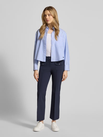 Frauenmodel trägt dunkelblaue Flared Fit Stoffhose mit Pattentaschen Modell 'Farah' von Cambio, elastischer Material-Mix, Ganzkörperansicht von vorne.