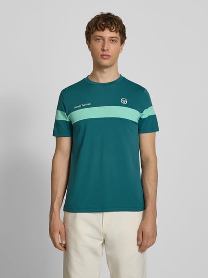 Männermodel trägt Regular Fit T-Shirt mit Logo-Print Modell 'Leone' von SERGIO TACCHINI in Türkis mit Rundhalsausschnitt, Ganzkörperansicht von vorne, Herren T-Shirt, Rückenlänge bei Größe M 71 cm.