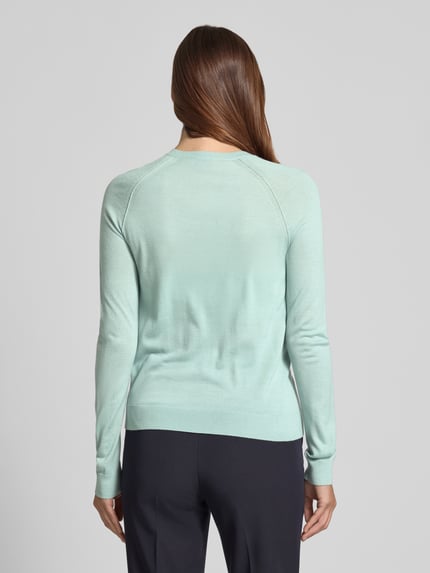 Frauenmodel trägt Regular Fit Strickjacke aus reiner Schurwolle Modell 'FONAMI' von BOSS, Optik: Unifarben, Feinstrick, Ganzkörperansicht Rückansicht.