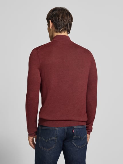Męski model nosi Slim Fit Strickpullover aus Woll-Mix mit Troyer-Kragen von Christian Berg Men, kolor bordowy, Długość tyłu w rozmiarze M: 72 cm, Długość rękawów w rozmiarze M: 69 cm, wykończenia: elastyczne, Ganzkörperansicht Rückansicht.