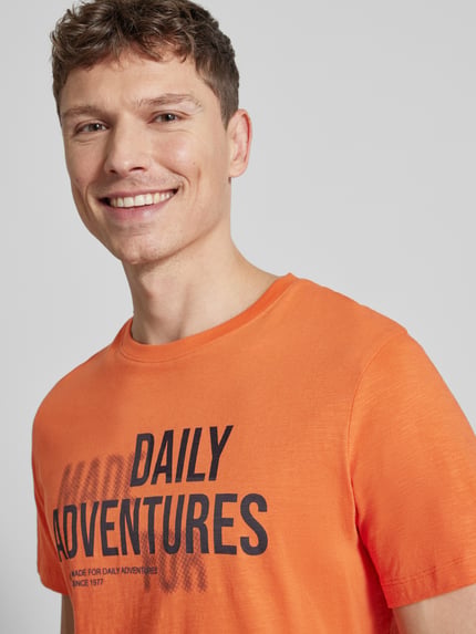 Männermodel trägt Regular Fit T-Shirt aus reiner Baumwolle von camel active, Herren T-Shirt mit Rundhalsausschnitt und Statement-Print, Nahaufnahme Oberkörper. Rückenlänge bei Größe M: 68 cm.