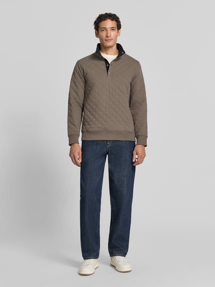 Männermodel trägt Regular Fit Troyer aus Baumwoll-Mix von GANT in taupe mit Stehkragen, Strukturmuster, Langarm, Ganzkörperansicht von vorne.