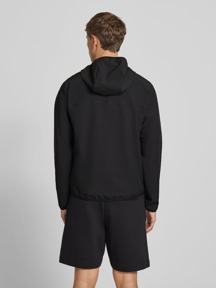 Männermodel trägt schwarze Regular-Fit Trainingsjacke mit Kapuze Modell 'LW_COMMUTERPRO' von BOSS aus BOSS Green, Ganzkörperansicht Rückansicht.