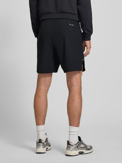 Männermodel trägt schwarze Shorts mit Logo und elastischem Bund von EA7 Emporio Armani, Material-Mix, Regular Fit, Ganzkörperansicht Rückansicht.