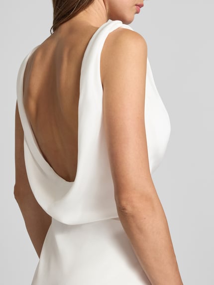 Frauenmodel trägt Abendkleid mit Wasserfall-Ausschnitt von Mascara in Weiß, Satin, breite Träger, Detailaufnahme Rückenansicht.