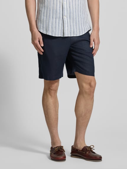 Männermodel trägt Shorts aus Leinen mit Gesäßtaschen von Gant in Dunkelblau, elastischer Bund, Regular-Fit, Nahaufnahme Oberschenkel.