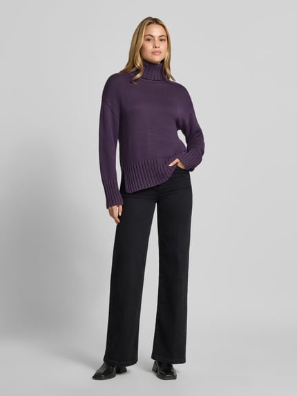 Frauenmodel trägt Relaxed Fit Strickpullover aus reiner Baumwolle mit Rollkragen von MOS MOSH in Lila, weiche Textur, elastische Abschlüsse, entspannte Passform, Ganzkörperansicht von vorne