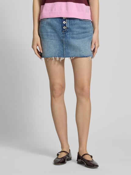 Vrouwenmodel draagt Mini-jeansrok uit puur katoen model 'GALANIE_1_B' van Hugo Blue, denimlook met studs, labelpatch, gestikt logo, riemlussen, contrastnaad, knoopsluiting, open zoom, 5-pocketmodel, smalle pasvorm, minilengte, puur katoen. Detailopname voorkant.