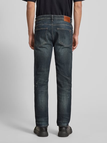 Męski model nosi Slim Fit Jeans aus Baumwoll-Mix Modell 'DELAWARE BO IMAGE' od BOSS Orange, efekt: jednolity kolor, efekt znoszenia, denim, wyhaftowane logo, naszywka z logo, detal z logo, szlufki na pasek, zapięcie na guzik i zamek błyskawiczny, 5 kieszeni, mieszanka bawełny; widok: całe ciało z tyłu.