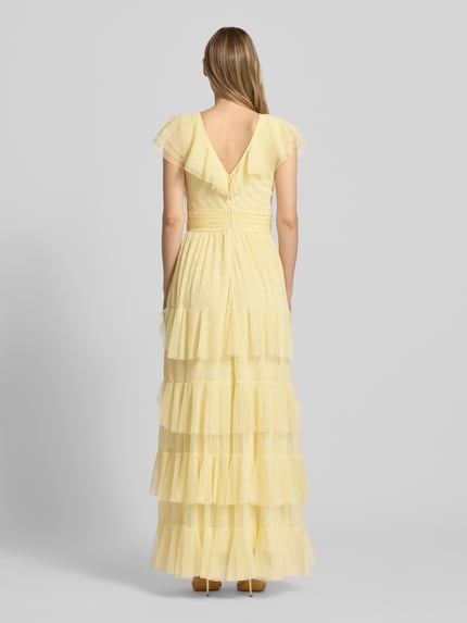 Vrouwenmodel draagt Maxikleid met V-hals en tailleband van LACE & BEADS, mesh, A-lijn, laagjeslook, ruglengte maat S 130 cm, borstwijdte 34 cm, zacht geel met transparante textuur, geheel van achteren.