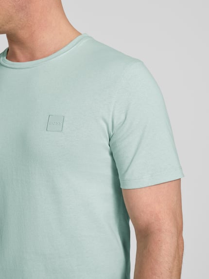 Männermodel trägt Regular Fit T-Shirt aus reiner Baumwolle Modell 'TALES' von BOSS Orange, Optik: Unifarben, Nahaufnahme Oberkörper