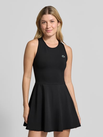 Kobiece modelka nosi Ausgestelltes Sport-Kleid mit Separate Innenhose od Lacoste, czarny materiał, gładka tekstura, nahaufnahme górnej części ciała, sukienka sportowa damska Lacoste Sport.