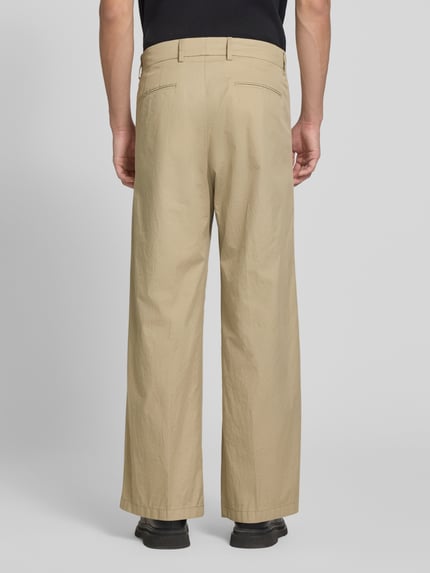 Männermodel trägt Stoffhose mit Biesen und Eingrifftaschen Modell 'LEEK' von Drykorn aus Reine Baumwolle, Wide-Fit, Ganzkörperansicht Rückansicht