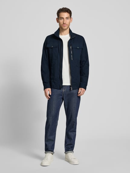 Männermodel trägt Regular Fit Jacke aus reiner Baumwolle von Tom Tailor in Two-Tone-Optik mit Reißverschluss, Eingrifftaschen, Innentasche, Ganzkörperansicht von vorne.