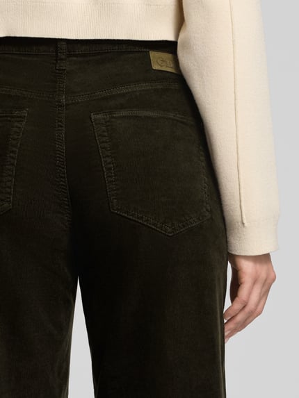 Frauenmodel trägt Barrel Fit Cordhose in verkürzter Passform Modell 'ELIN' von Cambio, Baumwoll-Elasthan-Mix, Gesäßtaschen, Nahaufnahme Rückansicht.