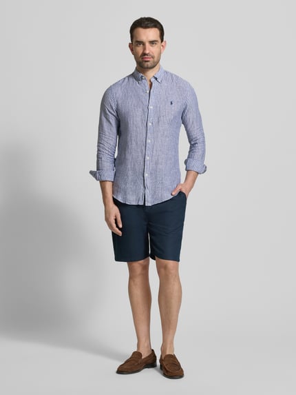 Männermodel trägt Slim Fit Freizeithemd aus reinem Leinen von Polo Ralph Lauren, Mehrfarbig, Gestreift, Button-Down-Kragen, Logo-Detail, Langarm, Einreihig, Rückenpasse, Flammgarn, Ganzkörperansicht von vorne.