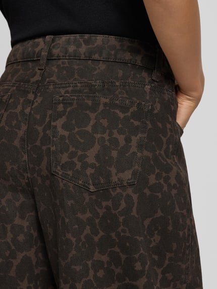 Frauenmodel trägt Wide Fit Jeans aus reiner Baumwolle mit Animal-Print von Oui, braune Grundfarbe, 5-Pocket-Design, Nahaufnahme Oberkörper, Kontext: Damen Jeans, Gürtelschlaufen, Knopf- und Reißverschluss, Bundweite 40 cm, Innenbeinlänge 69 cm.